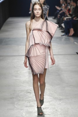 runway fashion photo of a woman in a complex pink dress