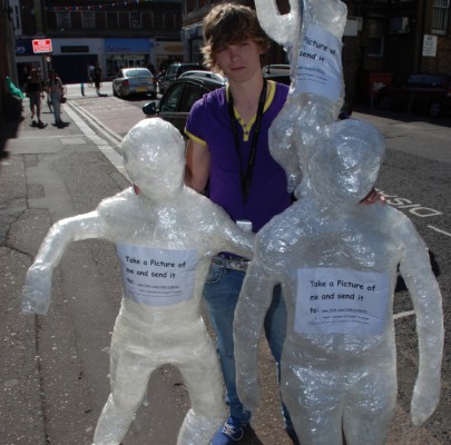 Young student holding 3 human figures made out of sellotape